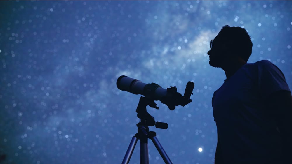 man watching stars with telescope