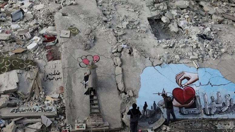 Graffiti artists paint the wreckage of houses destroyed in the earthquake