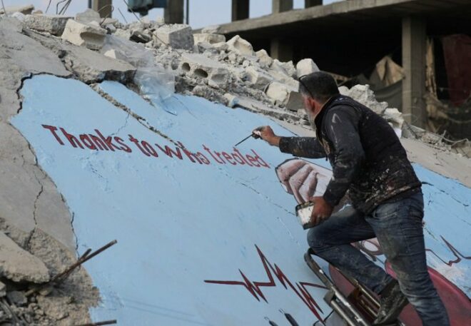 Graffiti artists paint the wreckage of houses destroyed in the earthquake 1 2